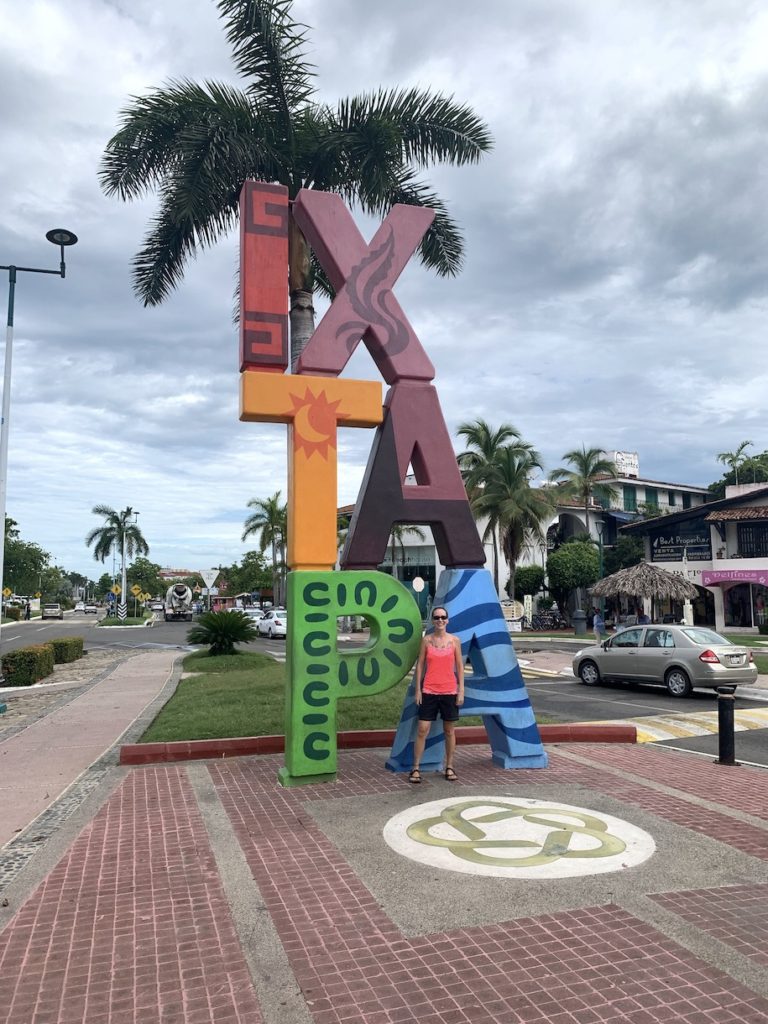 Mrs. ItchyFeet in front of Ixtapa sign