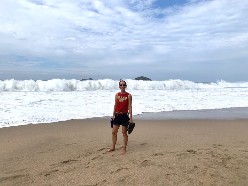 Mrs. ItchyFeet in front of really big ocean wave