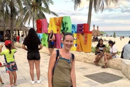 Mrs. ItchyFeet in front of Playa del Carmen sign