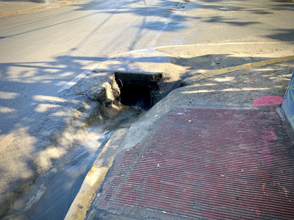 Open drain next to sidewalk