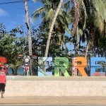 Mrs. ItchyFeet in front of Las Terrenas letters