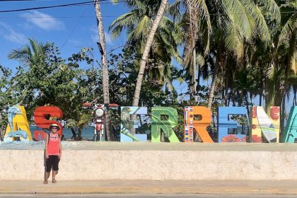 Mrs. ItchyFeet in front of Las Terrenas letters