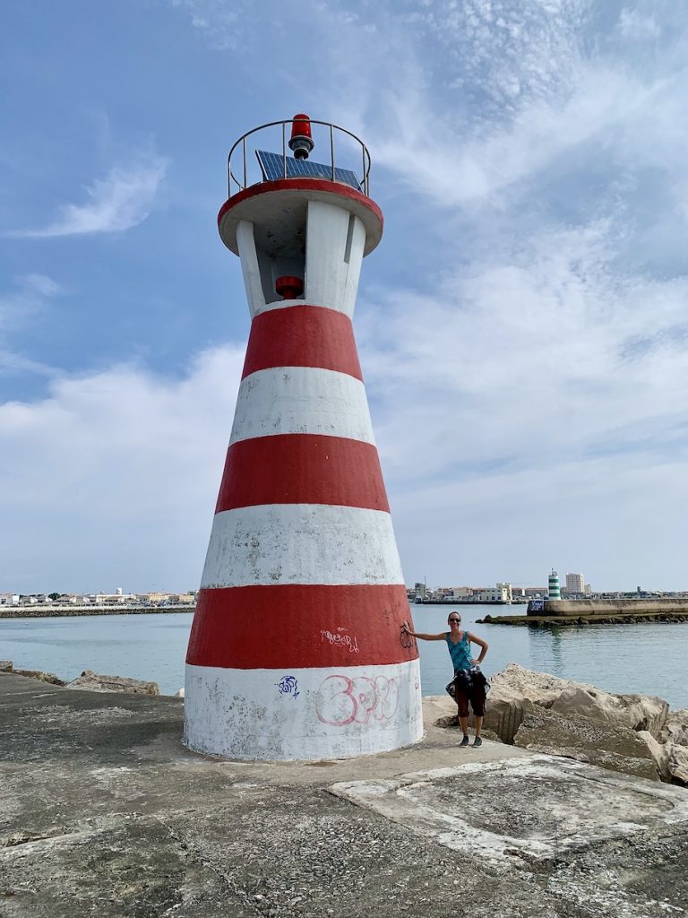 Mrs. ItchyFeet next to red and white lighthouse.