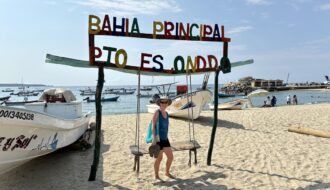 Mrs. ItchyFeet on Playa Principal with fisherman’s storage and sailfish statue in distance