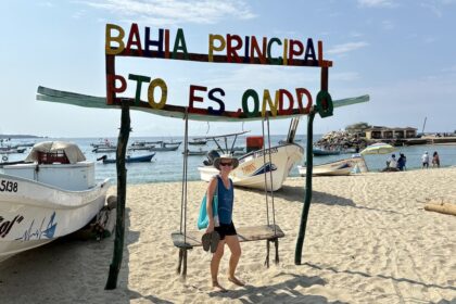 Mrs. ItchyFeet on Playa Principal with fisherman’s storage and sailfish statue in distance