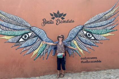 Mrs. ItchyFeet in front of wings mural