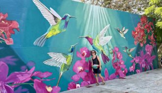 Mrs. ItchyFeet in front of hummingbird mural