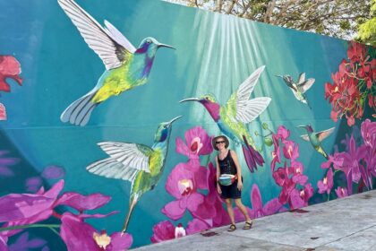 Mrs. ItchyFeet in front of hummingbird mural