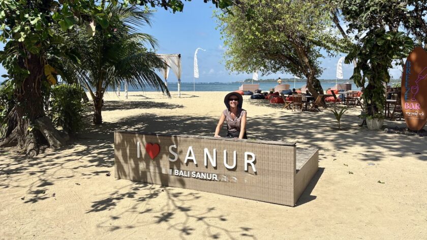 Mrs. ItchyFeet behind Sanur letters