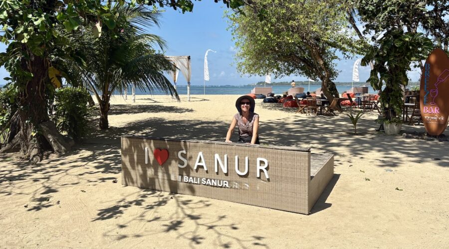 Mrs. ItchyFeet behind Sanur letters