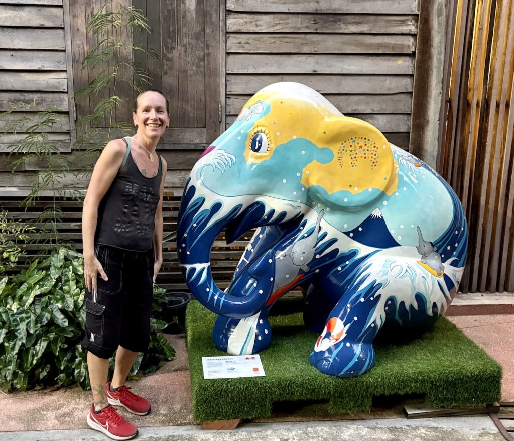 Mrs. ItchyFeet by colorful elephant statue