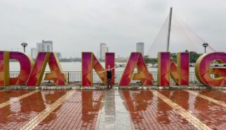 Mrs. ItchyFeet and Đà Nẵng letters in the rain