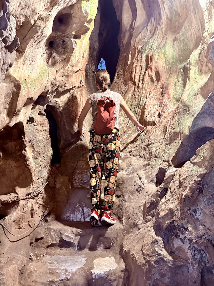 Mrs. ItchyFeet climbing through cave system